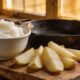 Cast iron skillet with golden potato wedges frying in tallow