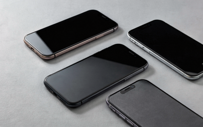 Several modern smartphones arranged on a minimal light surface