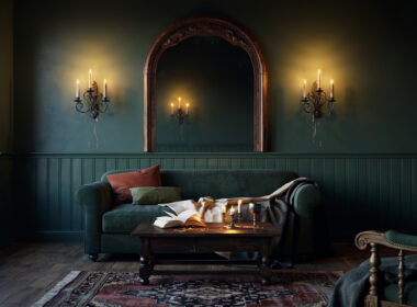 Moody fantasy inspired living room with deep green walls, arched mirror, and warm candlelight