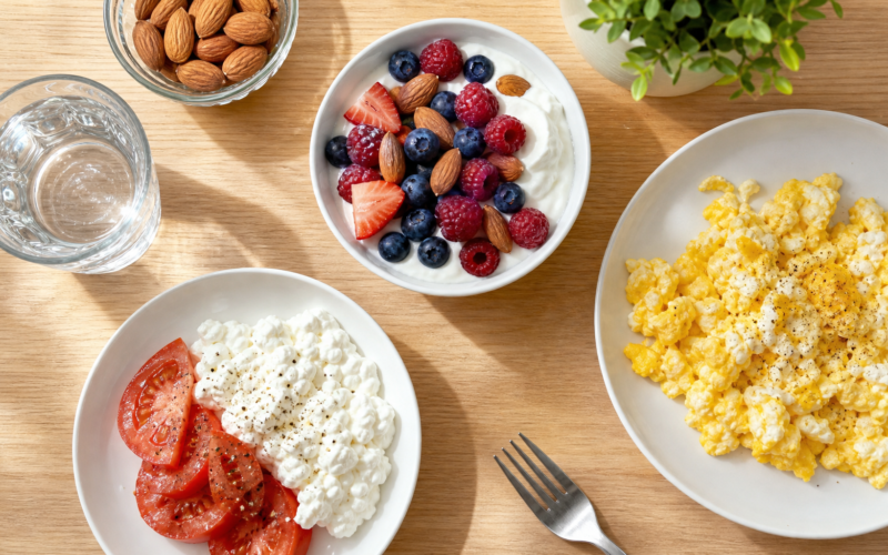 A high-protein breakfast spread with Greek yogurt and berries, scrambled eggs, and cottage cheese