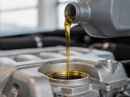 Fresh motor oil being poured into a car engine during an oil change