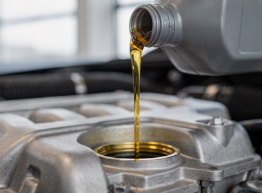 Fresh motor oil being poured into a car engine during an oil change
