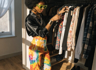 A stylish person choosing clothes from an open closet