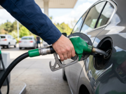 A hand refueling a car at a gas station fuel pump