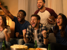 Sports fans cheering while watching a game together in a living room