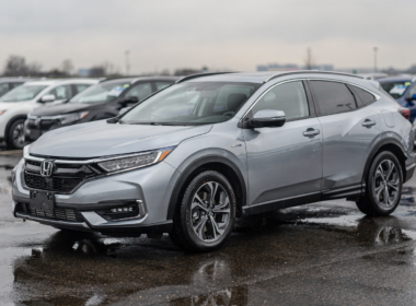 Silver hybrid crossover parked on a wet dealership lot after rain