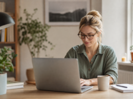 A person working from home at a tidy desk with a laptop and coffee