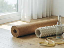 Recovery and mobility gear including a cork mat, foam roller, and resistance band in soft light