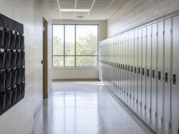 Row of school lockers in an empty hallway with a fabric phone storage pouch hanging beside them