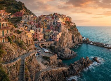 Colorful cliffside coastal village overlooking turquoise water at sunset