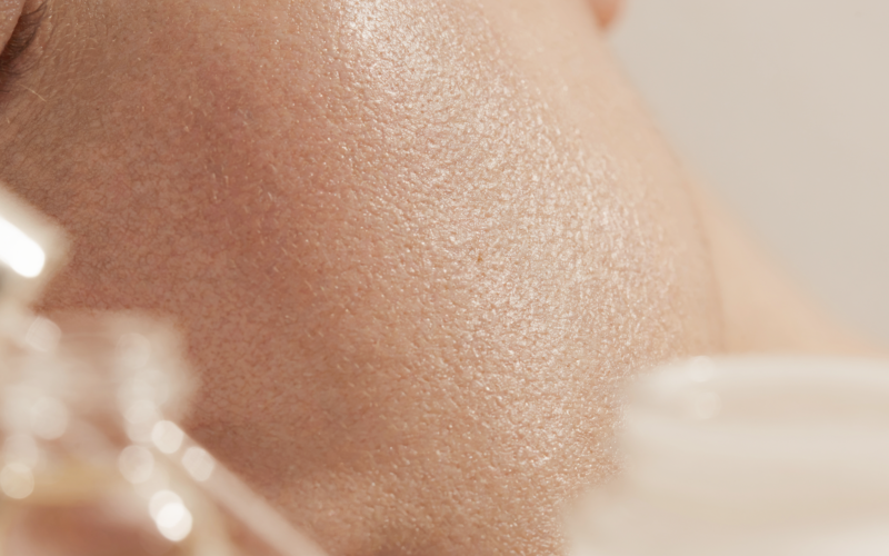 Close-up of luminous glowing skin with skincare products, illustrating a superhero skincare routine