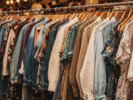Crowded rack of secondhand clothing in a bright thrift store