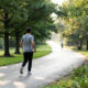 Person walking on a scenic tree-lined path in morning light showing the walking trend