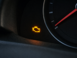 A car dashboard with an illuminated check engine warning light