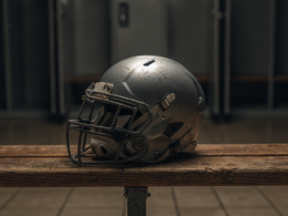 A lone football resting on a field at twilight, evoking a young quarterback at a career crossroads