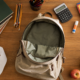Back to school spending shown as an empty canvas backpack, school supplies and a long blank receipt on a kitchen table