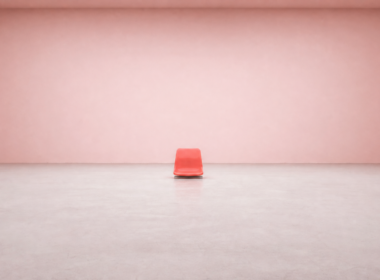 Single vivid coral stadium seat standing alone in a vast empty pale pink room