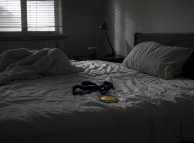 Big Brother 28 veto spoilers concept, gold medallion on a ribbon left on a rumpled bed at dawn