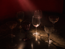 Six mismatched wine glasses on a dark table representing the Pick Your Poison veto competition in the Big Brother 28 episode 12 recap