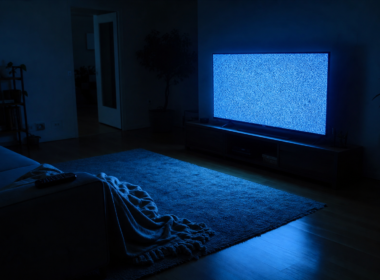 Big Brother 28 Episode 21 anticipation shown by a dim living room with a television glowing on empty static and an unoccupied couch