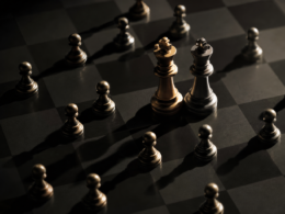 Big Brother 28 Icons concept: small pawns closing in on two king chess pieces on a dark board