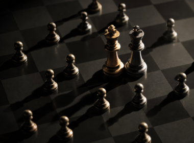 Big Brother 28 Icons concept: small pawns closing in on two king chess pieces on a dark board