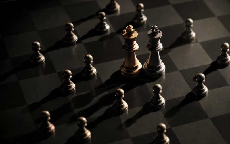 Big Brother 28 Icons concept: small pawns closing in on two king chess pieces on a dark board