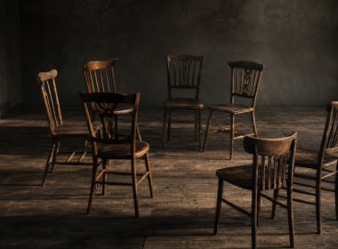 Big Brother 28 Mosh Pit alliance falling apart shown by a circle of seven wooden chairs with two turned away, breaking the ring