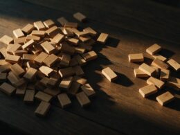 Big Brother 28 Week 6 spoilers illustrated by wooden voting markers sorted into two uneven piles on a dark table