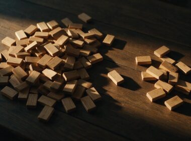Big Brother 28 Week 6 spoilers illustrated by wooden voting markers sorted into two uneven piles on a dark table