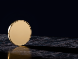 Bitcoin 75000 concept, blank gold coin balanced on edge on dark marble