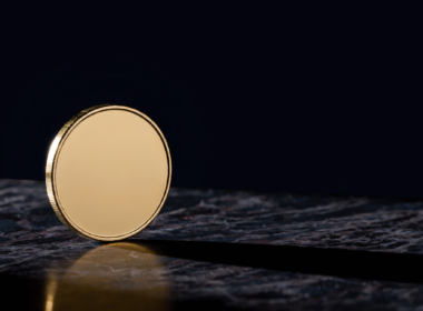 Bitcoin 75000 concept, blank gold coin balanced on edge on dark marble