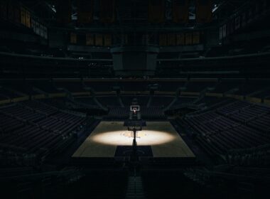 Buss family Lakers stake sale illustrated by a darkened empty arena with a spotlight on center court