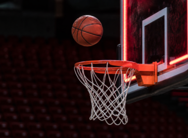 Chelsea Gray buzzer beater concept with a basketball frozen in mid air above the rim in an empty arena
