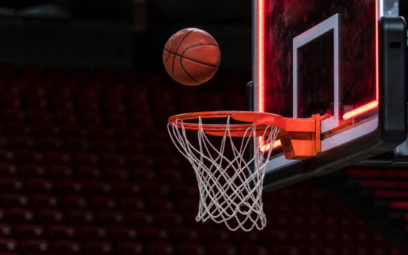Chelsea Gray buzzer beater concept with a basketball frozen in mid air above the rim in an empty arena