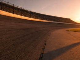 Empty high banked oval speedway photographed from trackside at golden hour
