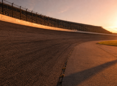 Empty high banked oval speedway photographed from trackside at golden hour