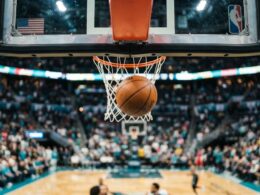 Kanter Freedom Natasha Cloud concept, low angle under a basketball rim in a packed bright arena