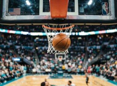 Kanter Freedom Natasha Cloud concept, low angle under a basketball rim in a packed bright arena