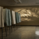 Florida primary governor race shown by empty voting booths in a polling place at night with palm shadows on the wall