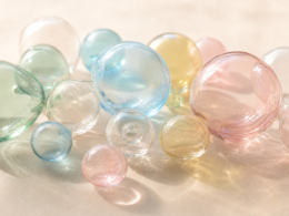 Hugging Face sale concept, cluster of translucent pastel glass spheres in soft daylight