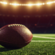 A football stadium at dusk with a rising spotlight, symbolizing high expectations for a young quarterback