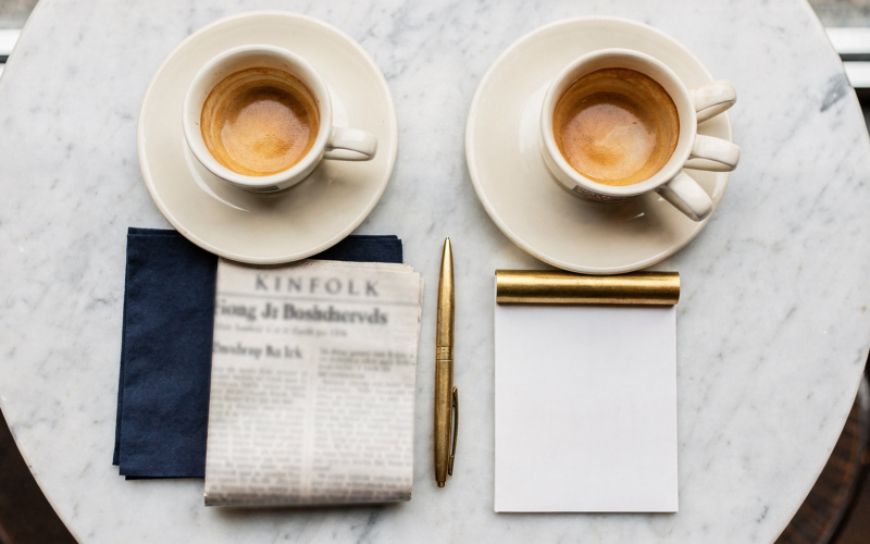 Jeffries Kushner meeting concept, overhead flat lay of two espresso cups on white marble