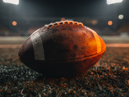 An empty football field under stadium lights, representing a team built to contend