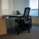 Quits rate decline illustrated by an empty office desk with the chair pushed in and an unopened flat moving box on the floor