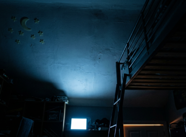 Meta child addiction trial, dark bedroom ceiling lit cold blue from an unseen screen below