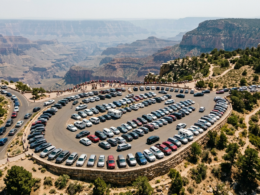 National park crowds shown as tightly packed rows of parked cars at a canyon scenic overlook viewed from above