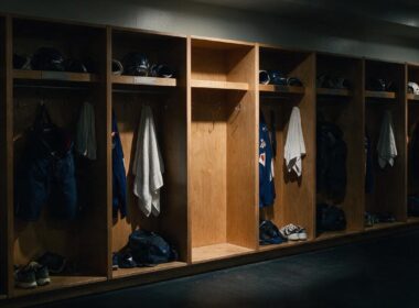 Peyton Watson trade illustrated by a dim locker room with one stall stripped bare among a full row of gear