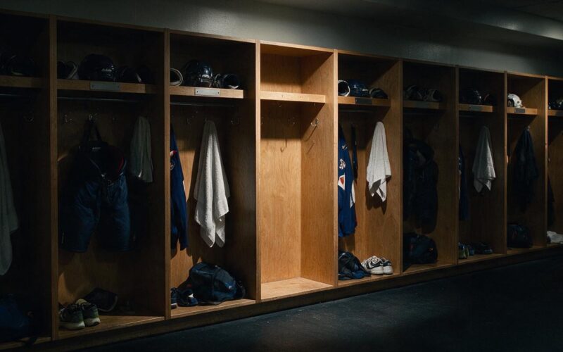 Peyton Watson trade illustrated by a dim locker room with one stall stripped bare among a full row of gear