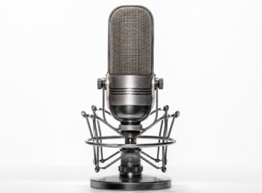 Vintage ribbon microphone on a chrome shock mount against a clean seamless white background